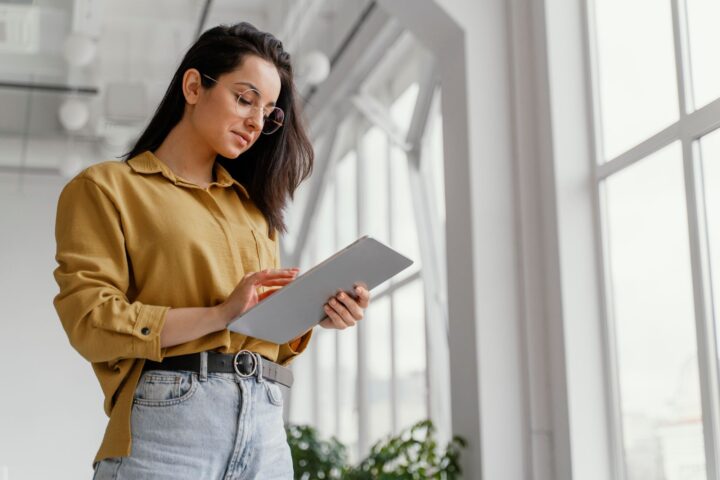 young-businesswoman-checking-her-tablet-with-copy-space